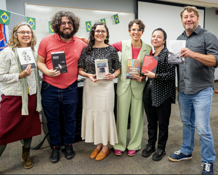 Faculty and Students with Books Smiling