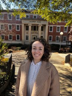 María smiles in front of Gilbert Hall